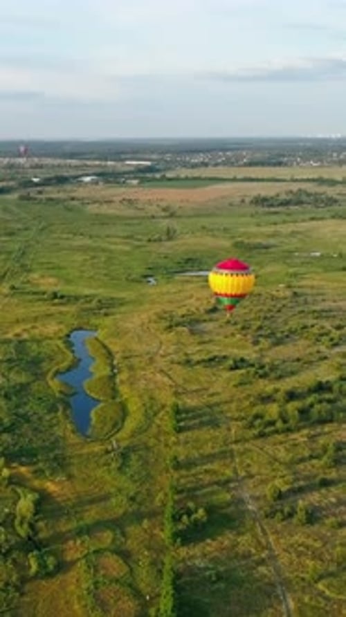 Colorful hot air balloon. Aerial view of air balloon over fields