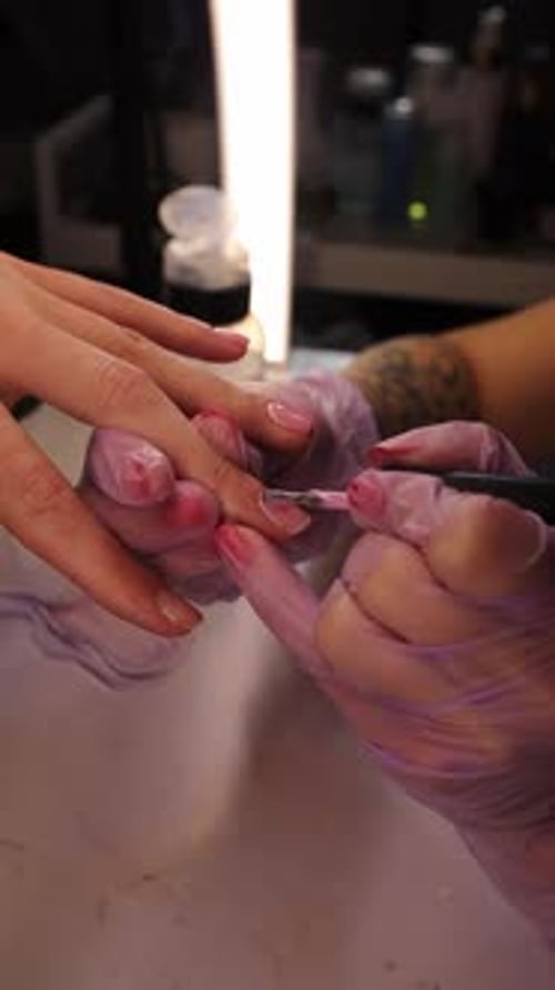 Close Up of Professional Manicure Process Nail Technician Applying Gel Polish on Female Nails with