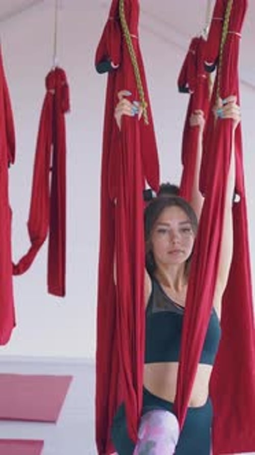 Young Adults Doing Aerial Yoga in Hammocks