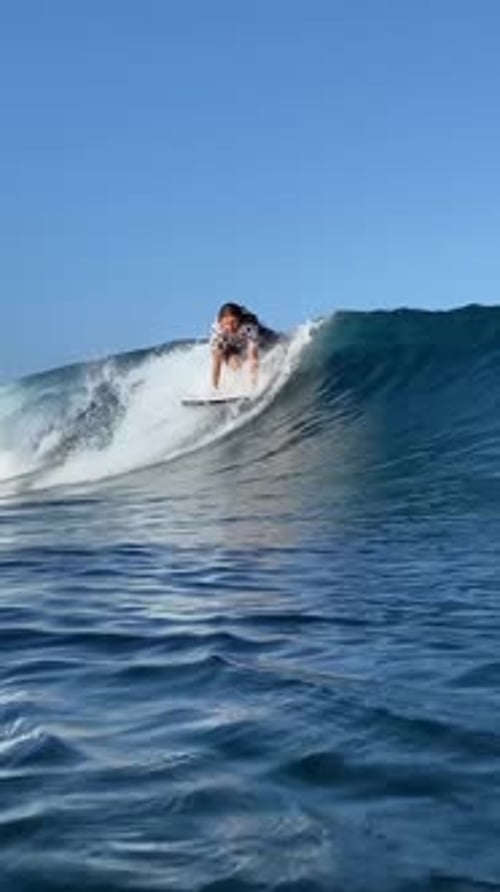 Young Guy Surfs in the Ocean