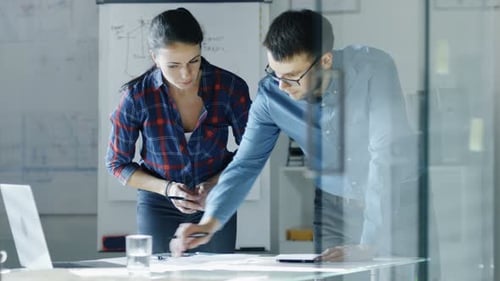 Männliche und weibliche Konstrukteure arbeiten an Entwürfen, nehmen Korrekturen vor und besprechen ihr Projekt. Auf dem