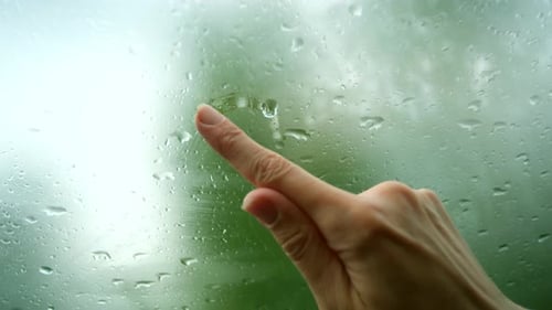 Drawing Heart on Rainy Glass Window