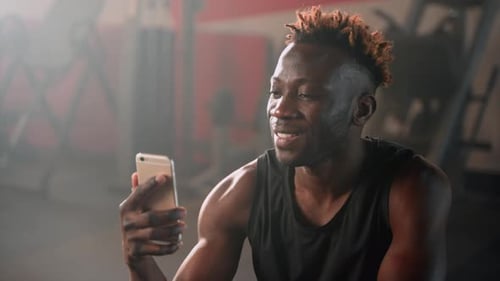 Young Adult Video Chatting at the Gym