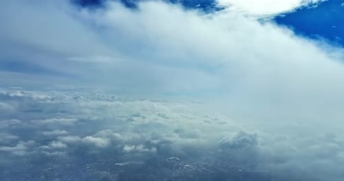 Aerial drone footage flying high above the clouds, capturing smooth movement of cloud layers