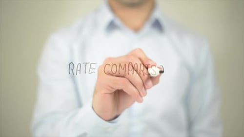 Man Writes Rate Comparison on Clear Surface