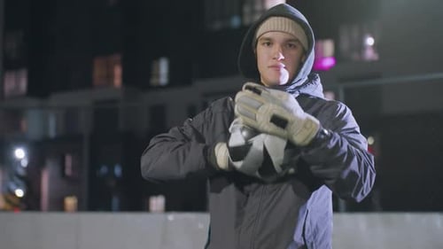 Coach Rolling Soccer Ball During Nighttime Training on Urban Sports Field