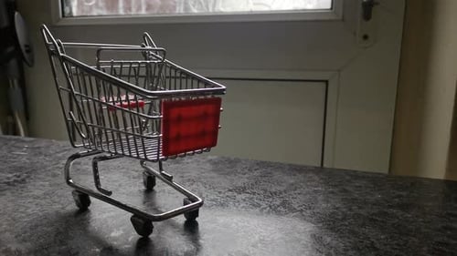 Mini empty shopping cart online home supermarket concept copy space closeup slow reverse dolly right