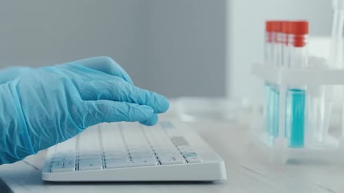 Scientist Typing Data in Modern Laboratory