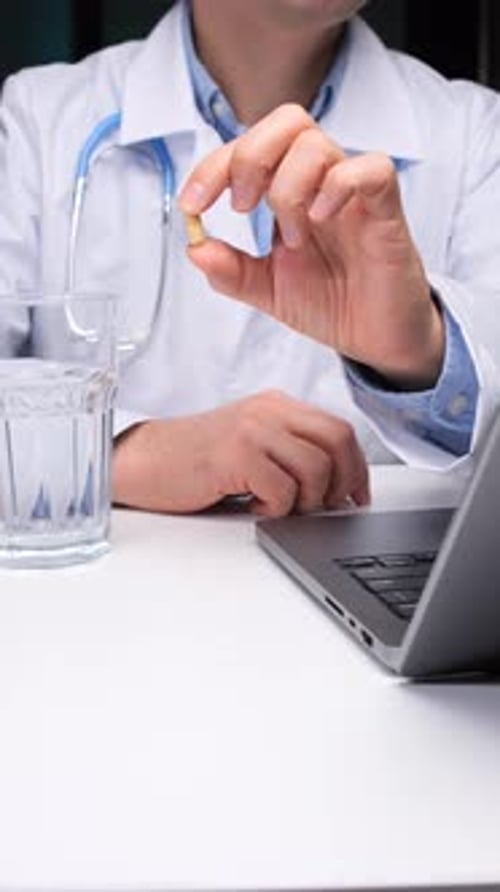 Medical Professional Holding Pill With Glass of Water