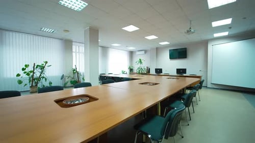 Conference hall in modern medical centre. Big light meeting room with long table and screen