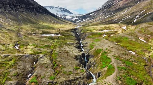 River Flows in a Mountain Crevice Flight Along the Canyon Nature in Iceland