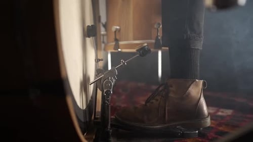 Close up of a drummers foot pressing the kick pedal of the drum kit while the camera tracks towards