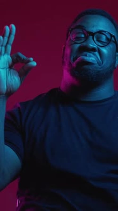 Person Making Okay Sign in Blue and Red Lights