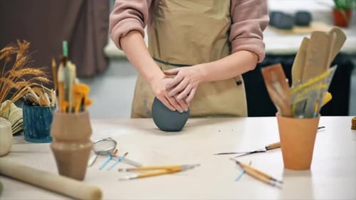 The master of sculpting pottery working in a studio. Kneading a piece