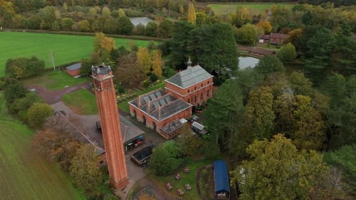 Overhead Aerial Drone View of Historic Pumping Station Hidden in Forest During Autumn Season in