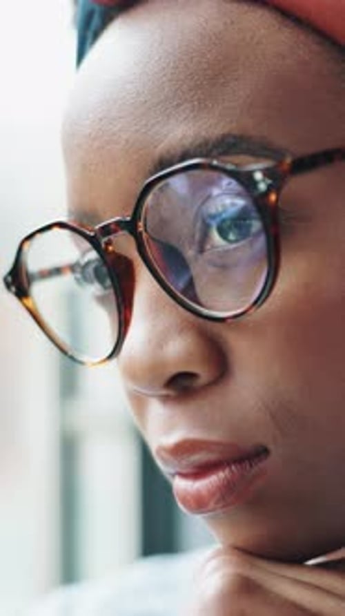 Black woman, thinking and reflection at window in home, glasses or insight for decision in lounge