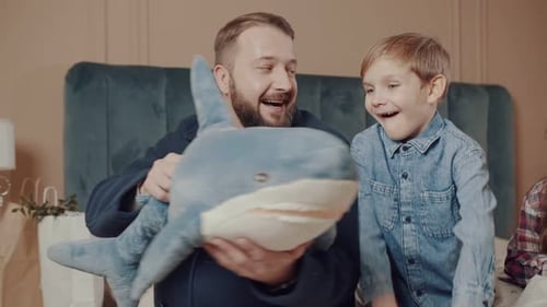 Dad Presents Blue Shark Toy to Happy Children