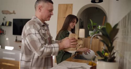 Couple Washing Dishes Together in Bright Kitchen
