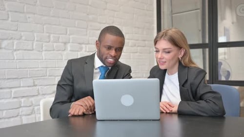 Business Colleagues Collaborating on Laptop in Modern Office