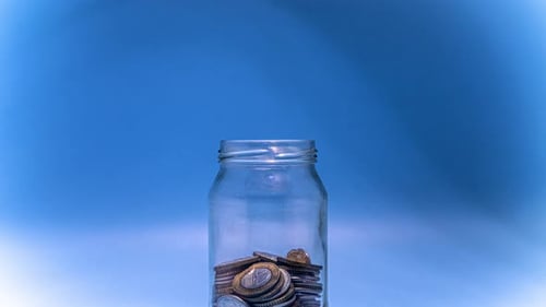 Time Lapse of Coins Filling a Glass Jar