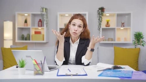 Home office worker woman looking nervously at camera.
