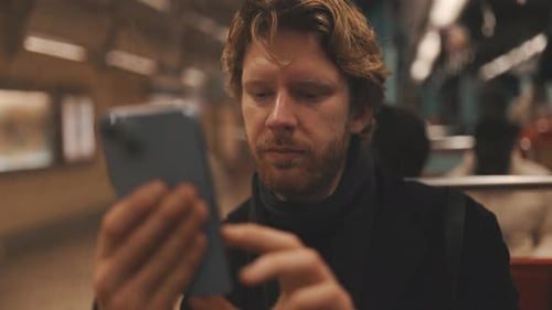 Man Using Mobile Phone on Public Transportation