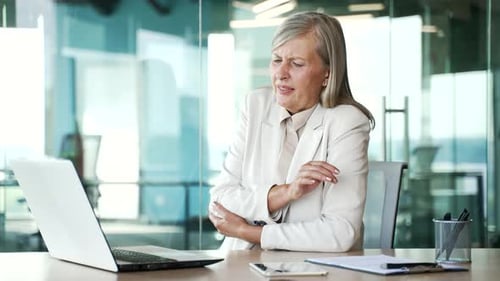 Woman with Arm Pain at Office Desk