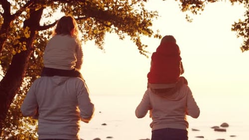 Loving Family Walks in the Countryside During Sunset Mom and Dad Hug and Play with Their Son and