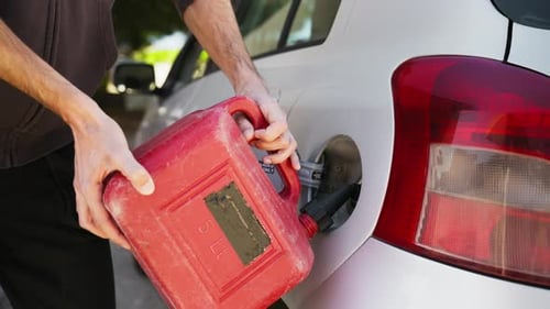 Refilling a White Car Using a Red Plastic Gas Can