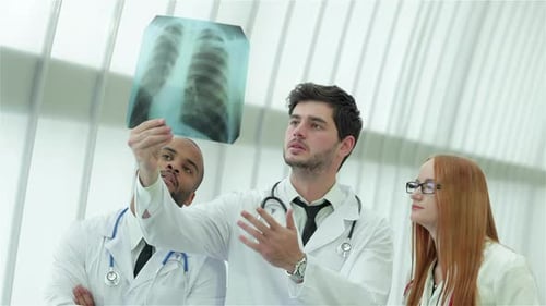 Three Confident Doctor Examining Xray Snapshot of Lungs in Hospital
