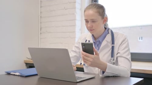 Young Female Doctor Using Smartphone in Hospital