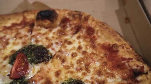 close up shot of delicious Italian pizzas delivered in boxes on the wooden table at home, zooming ou