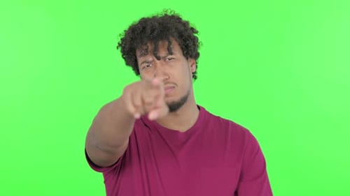 African Man Pointing at the Camera on Green Background