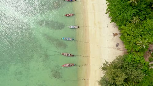 Boats near shore of island. Traditional colorful fishing vessels floating on calm blue water near wh