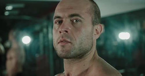 Close up of male bodybuilder's sweaty face while inside the gym