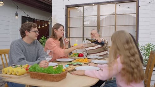 Multiracial family having fun and enjoying party outdoors in garden.