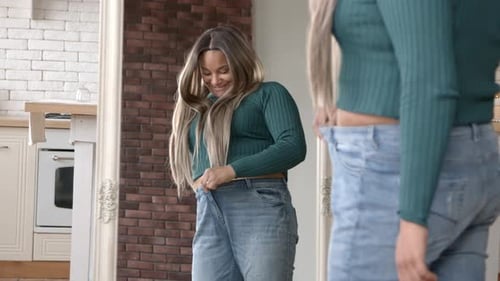 Woman Shows Weight Loss in Mirror at Home