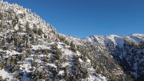 Aerial of a road through the mountains after a snow