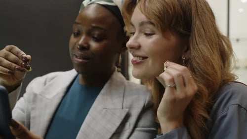 Two Young Women Taking Selfie while Admiring Elegant Earrings in Shop
