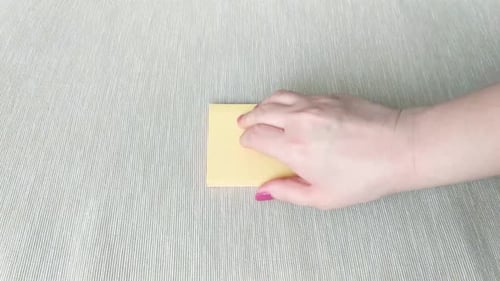 Female Hand Peels Off Yellow Sticky Note