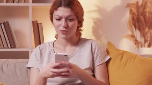 Woman Using Smartphone Expressing Surprise Indoors
