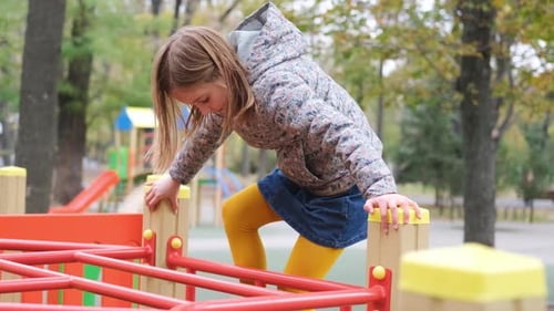 Little Girl Climbing on Top of Playground
