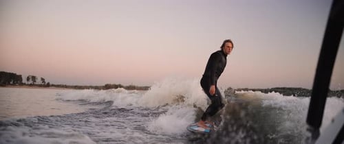 A Skilled Surfer Riding Waves at Dusk Captivating Moments of Balance Agility and Adventure in a