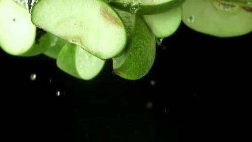 Pieces of Green Apples Fall Under the Water Filmed on a Highspeed Camera at 1000 Fps