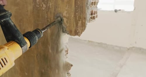Dismantling the Walls in the Premises Builder Removes Plaster with a Jackhammer