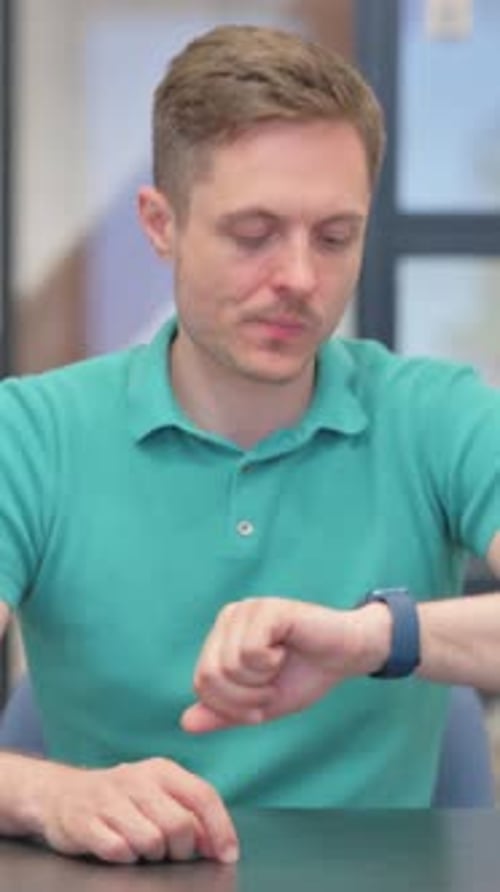 Man Checking His Watch While Sitting Indoors