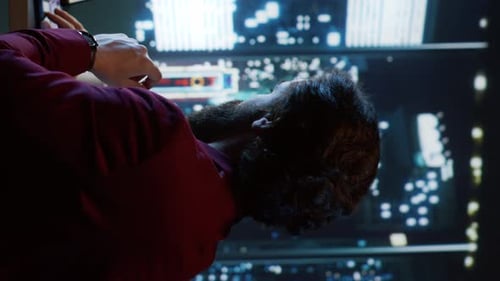 Man Working at Computer Monitors at Night