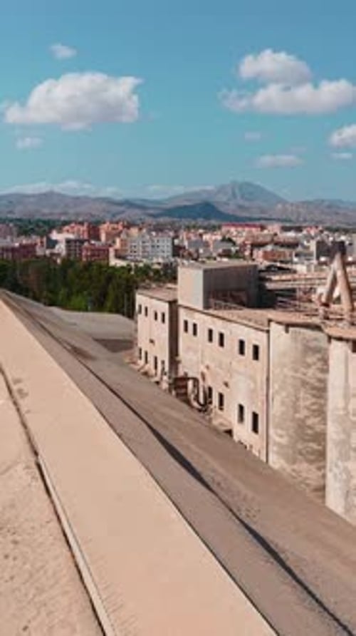 Abandoned Industrial Factory Rooftop with City and Mountains in the Background