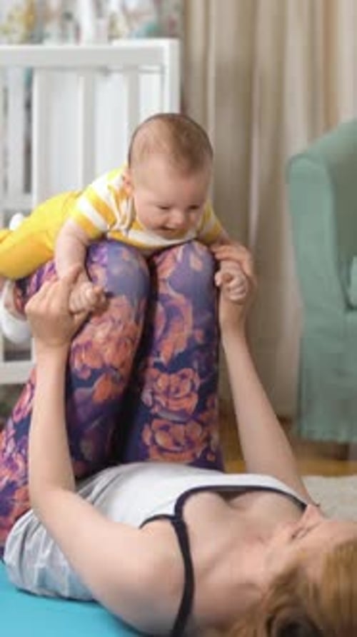 Mother Lying Down Doing Baby Exercise