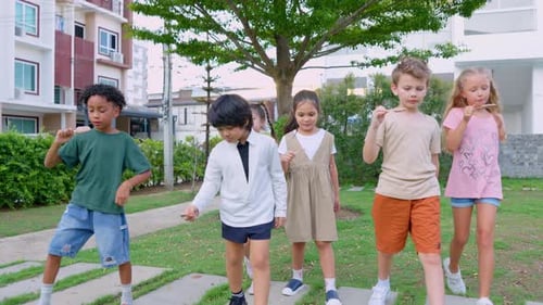 Group of children eating an ice cream in the garden of elementary kindergarten.
